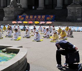 对着法轮功学员单腿下跪的温哥华市民安吉